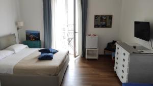 萨莱诺Marchesa Lulu的一间卧室配有一张床、梳妆台和电视。