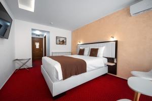 旧瓦马Km ZerO - Vama Veche的酒店客房配有一张大床和红地毯。