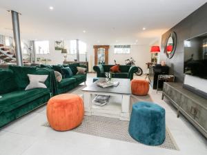 卡纳芬Capel Mawr, Basement 19的客厅配有绿色沙发和橙色椅子