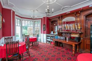 鲍内斯温德米尔Elim Bank Guest House的一间拥有红色墙壁和桌椅的用餐室