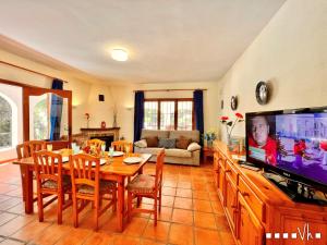 特乌拉达VH CostaBlanca - CARMEN的客厅配有餐桌和电视