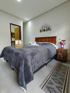 蒂拉登特斯Pouso Casa da Vovó的一间卧室配有一张大床和大毯子