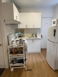 多伦多Private Double Room with Shared Bathroom 536B的厨房配有白色橱柜和白色冰箱。