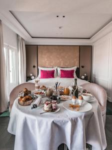 巴黎Fauchon l'Hôtel Paris的一张桌子,上面有食物,放在床前