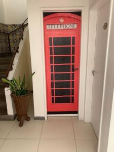 累西腓Pousada Lorde Inglês的走廊上的红色电话亭,有楼梯