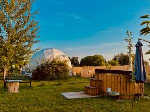 纳文丘夫Glamping Stacja Zieleniec w Nałęczowie的圆顶帐篷,带围栏和雨伞