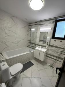 哈斯科沃Хотел АВРОРА的浴室配有卫生间、盥洗盆和浴缸。