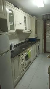 诺哈Skala的白色的厨房配有白色橱柜和水槽