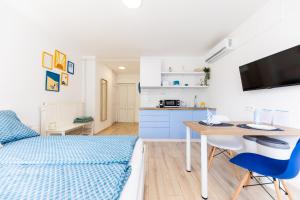 巴拉顿诺尔马迪Balaton Wave Apartments的客房设有一张床、一张书桌和一间厨房