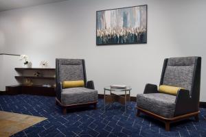 基恩基恩市中心万怡酒店的一间设有两把椅子和一张桌子的等候室