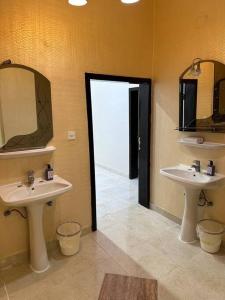Rabbaشقه كبيره بتصميم انيق وفناء خارجي的浴室设有2个水槽、2面镜子和1个门廊。