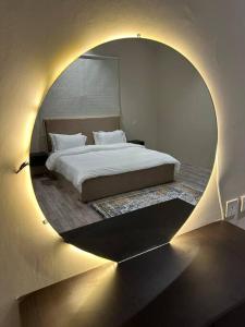 Rabbaشقه كبيره بتصميم انيق وفناء خارجي的一间卧室配有一张带圆镜子的床
