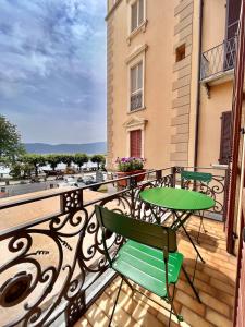韦尔巴尼亚Casa Gambusso historical house magnificent Lake View的阳台配有绿色的桌椅