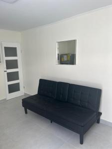 奥拉涅斯塔德Klip lagoon apartsments的一张黑色沙发,位于带镜子的房间里