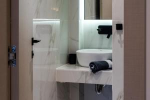 法纳里恩NERO SEASCAPE SUITES的白色的浴室设有水槽和镜子
