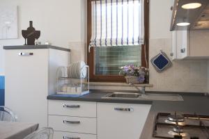 波尔图桑特埃尔皮迪奥Casavacanze Azzurro Mare的厨房配有白色橱柜、水槽和窗户。