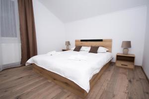 克利默内什蒂Casa Calina的卧室配有一张白色的大床,铺有木地板