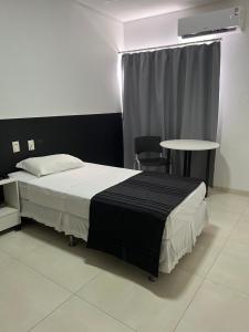 阿拉瓜伊纳圣维森特酒店的一间卧室配有一张床、一张桌子和一个窗户。