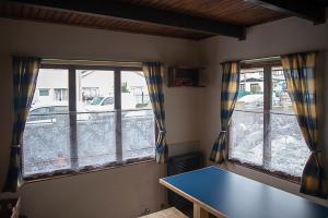乌斯怀亚Holger sofus的客房设有2扇窗户,配有蓝色的桌子