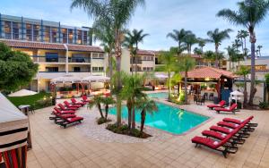 尔湾奥兰治县中庭酒店的一个带躺椅的度假游泳池和一间酒店