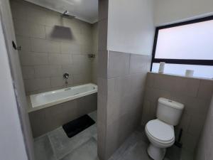 波罗瓜尼East Park Inn的一间带卫生间和浴缸的浴室