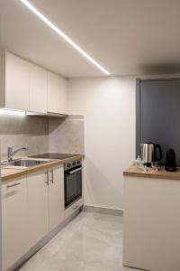 雅典La Residence Athens的厨房配有白色橱柜和水槽