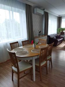沃鲁Võru Villa, saun, grill, jalgrattad, ideaalne perepuhkus!的客厅配有餐桌和椅子