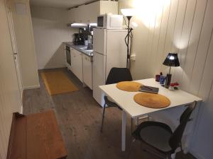 波多Sokkelleilighet rett ved Saltstraumen的一间带桌子和冰箱的小厨房