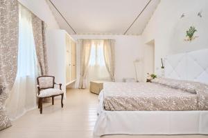 里米尼Agriturismo Borgonuovo的白色卧室配有床和椅子