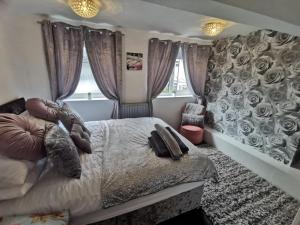 麦克尔斯菲尔德Stunning 2-Bed House in Macclesfield Cheshire的一间卧室设有一张床和一堵玫瑰墙