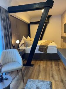 比斯平根Hotel Harmshof Bispingen的一间卧室配有一张床、一把椅子和镜子