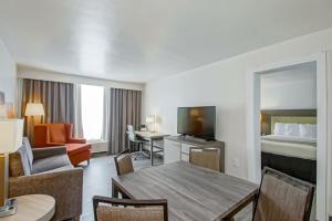 新奥尔良Country Inn & Suites by Radisson, New Orleans I-10 East, LA的酒店客房带一张床、一张桌子和椅子