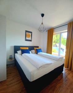滨湖席弗灵Ferienwohnung Lucia的卧室设有两张床和大窗户