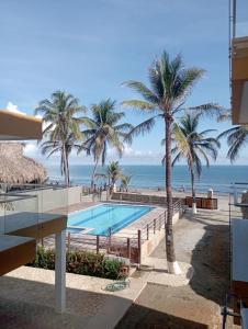 圣贝尔纳多德尔比恩托NAHIR apartamento de playa en condominio Palmar del viento的从度假村的阳台上可欣赏到海滩景色