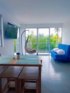 圣贝尔纳多德尔比恩托NAHIR apartamento de playa en condominio Palmar del viento的客厅配有桌子和蓝色沙发