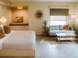 塔尔萨Brut Hotel的一间卧室配有一张床和一张沙发