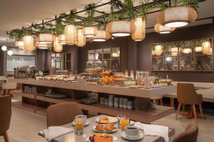 里韦拉Like Design Hotel Rivera的在餐厅享用自助早餐,餐桌上供应食物