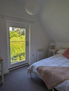 HernehillMyrtle Stables - converted, self-contained, countryside的一间卧室设有一张床和一个大窗户