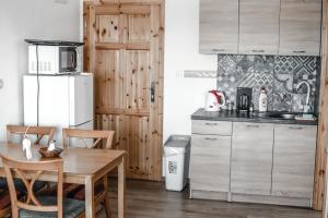 波达雅斯卡Rezidencia Podhájska的厨房配有木桌和冰箱。