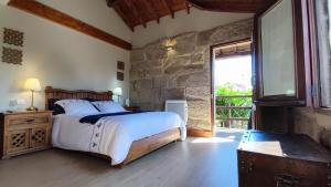 Sabariz萨巴里斯田园酒店的一间卧室设有一张床和石墙