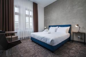比尔森Riverside Hotel Plzeň的一间卧室配有一张大床和蓝色床头板