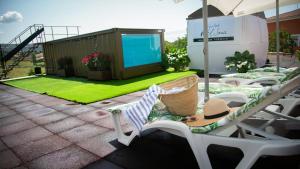 NohalesHabitaciones Casa Rural El Sauce的庭院设有草坪椅和位于房子的屏风