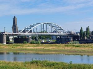 阿纳姆Medina B&B hartje Arnhem的一座桥,在水体上,有钟楼