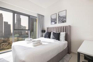 迪拜SmartStay at Burj Royale - Full Burj Khalifa View - Brand New Luxury Apartments的卧室设有一张大白色的床和大窗户