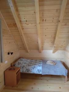 新瓦罗什Brvnara Srna Zlatar的小木屋内木制房间的一个床位