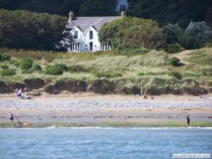 波特艾农Culver House Hotel的一群人住在海滩上,有房子