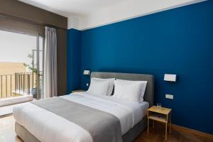 雅典Nileos House的蓝色的卧室,配有一张蓝色墙壁的床