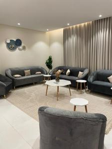 艾卜哈نزل ليلى الفندقية الفاخرة luxury的客厅配有蓝色的沙发和桌子
