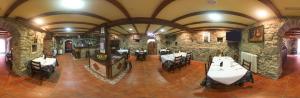 Outeiro欧特罗乡村旅馆的石头建筑中带桌椅的餐厅