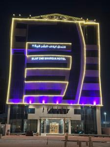 Sīhātفندق ايلاف الشرقية 2 Elaf Eastern Hotel 2的一座大建筑前面有紫色的灯